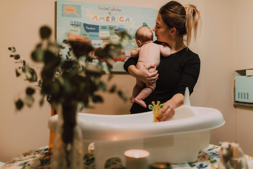 🛁 Bagnetto Neonato: Quando, Quanto Spesso e Come Farlo in Sicurezza 2 bagnetto neonato con mamma che prepara asciugamano e prodotti delicati