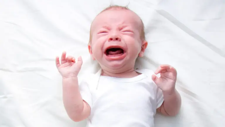 Neonato che piange sempre nella culla, visibilmente agitato